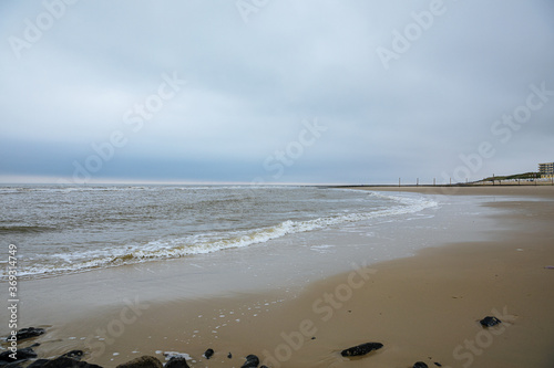 Fototapeta Naklejka Na Ścianę i Meble -  Landscape photo with the North Sea and a beach on an East Frisian island. North Sea with wind and clouds