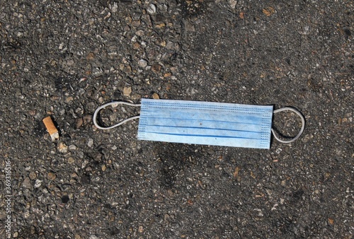 Athens, Greece,  August 1 2020 - Surgical face mask thrown on the ground at the port of Piraeus. © Theastock