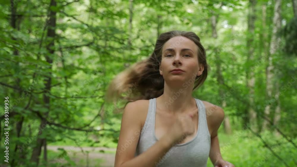 Young female athlete running through the woods Young female athlete running through the woods