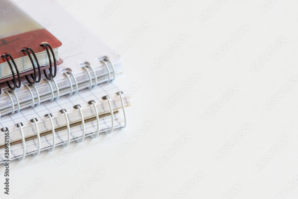 photo of several spiral bound notebooks on a white background in a minimalistic style, office theme
