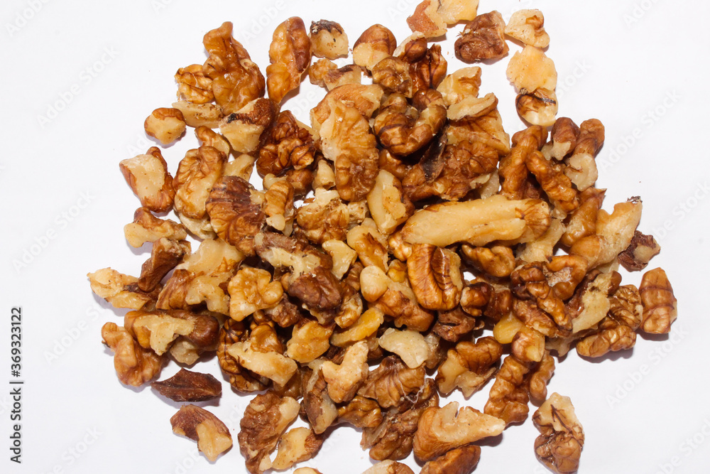 Close up shot of brown broken walnut seeds in white background
