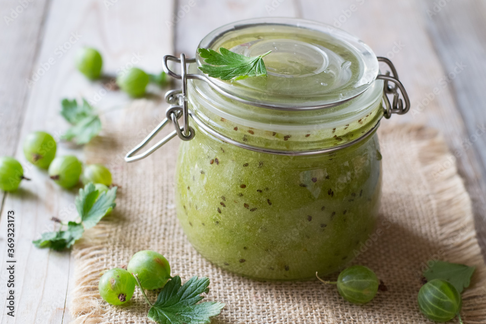 Gooseberry jam in jar on wooden table Gooseberry jam in jar on wooden table