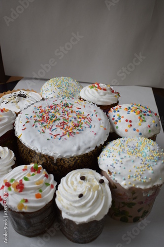 Easter cakes with candied fruit  white glaze and sprinkles  fresh  side view  on a white background and on a dark background in the package with multi-colored sprinkles the view from the top big and s