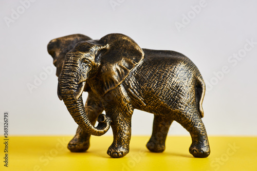 Studio shot of antique metallic elephant figurines on a black background
