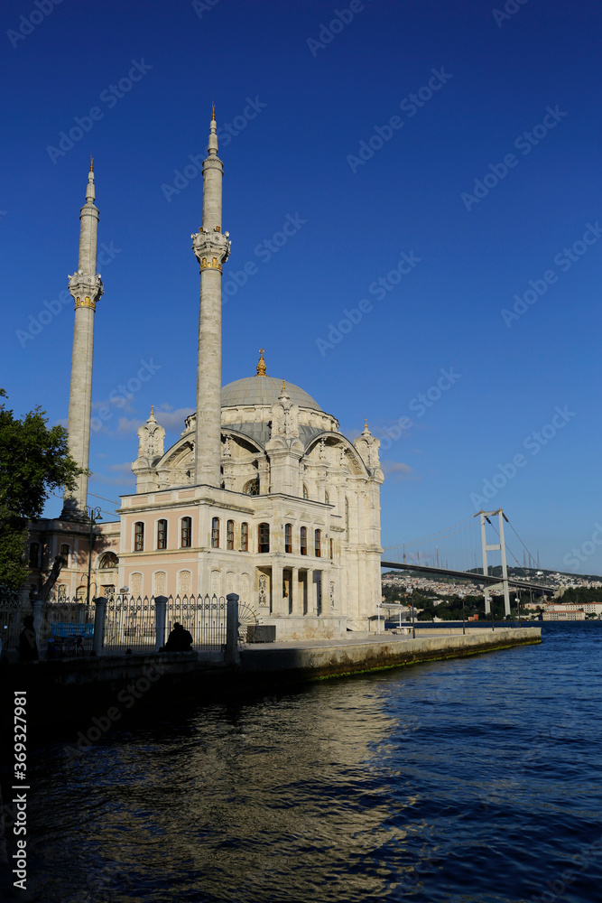 The Ortakoy mosque, also known as Buyuk Mecidiye, is seen backgrounded by 15 July Martyrs bridge in Bosporus strait, Istanbul, Turkey.