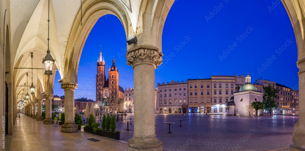 Main market square, Cloth Hall arcades and St Mary's church in the night, Krakow, Poland