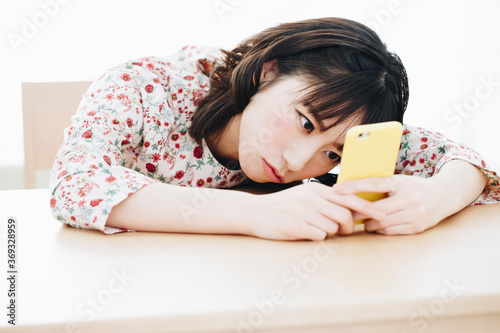 Fotografía スマホを見て落ち込む女性