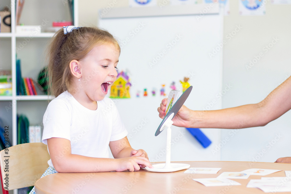 developmental and speech therapy classes with a child-girl. Speech therapy exercises and games with a mirror and cards