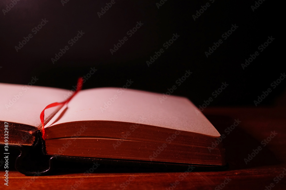Open book on the table on dark background.