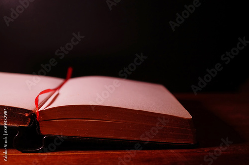 Obraz na płótnie Open book on the table on dark background. w salonie