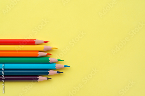 Colorful pencils on yellow paper