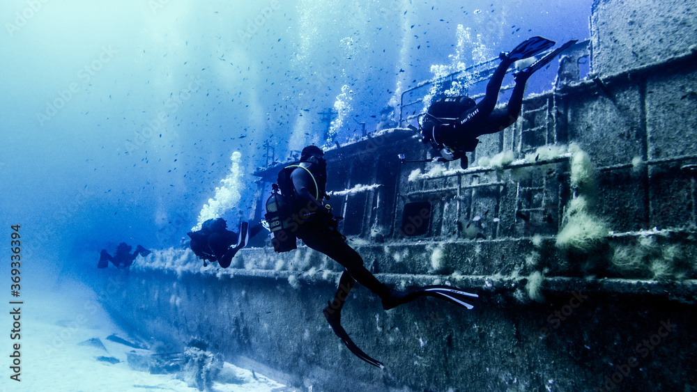 Scubadiving. Scuba divers diving at the shipwreck.