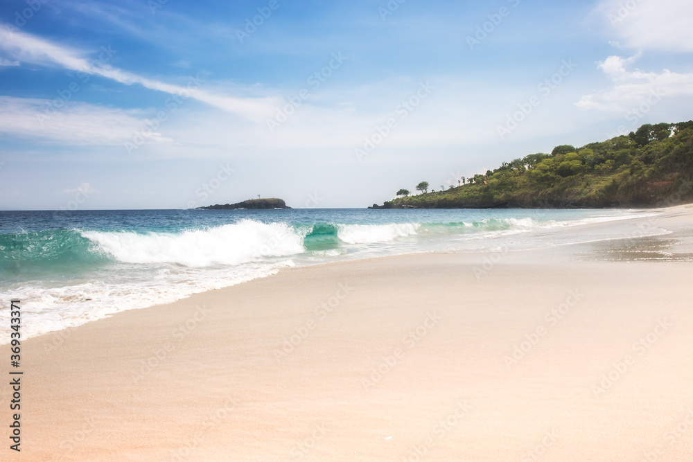 Virgin white sand beach Bali with turquoise sea water big waves blue sky 