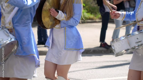 Close-up of female hands drummers are knocking in the drum of their sticks. Majorettes in the parade