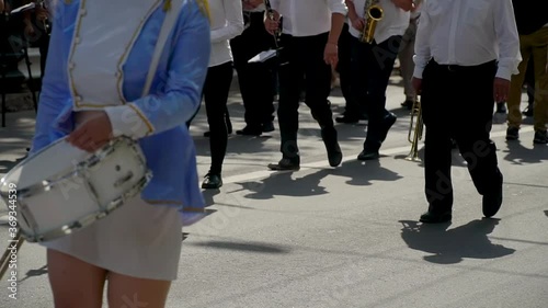 Street performance of festive march of drummers girls in blue costumes on city street. Close-up of female hands drummers are knocking in the drum of their sticks