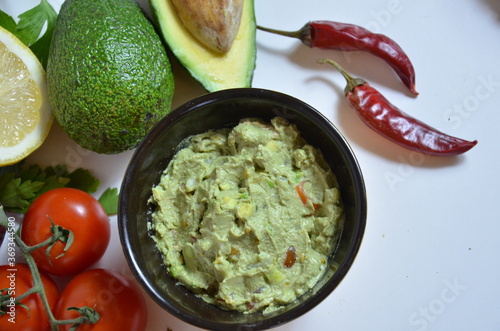 Girl make a sandwich Guacamole and bread. Toast with avocado on white background. Homemade Mexican healthy vegan food