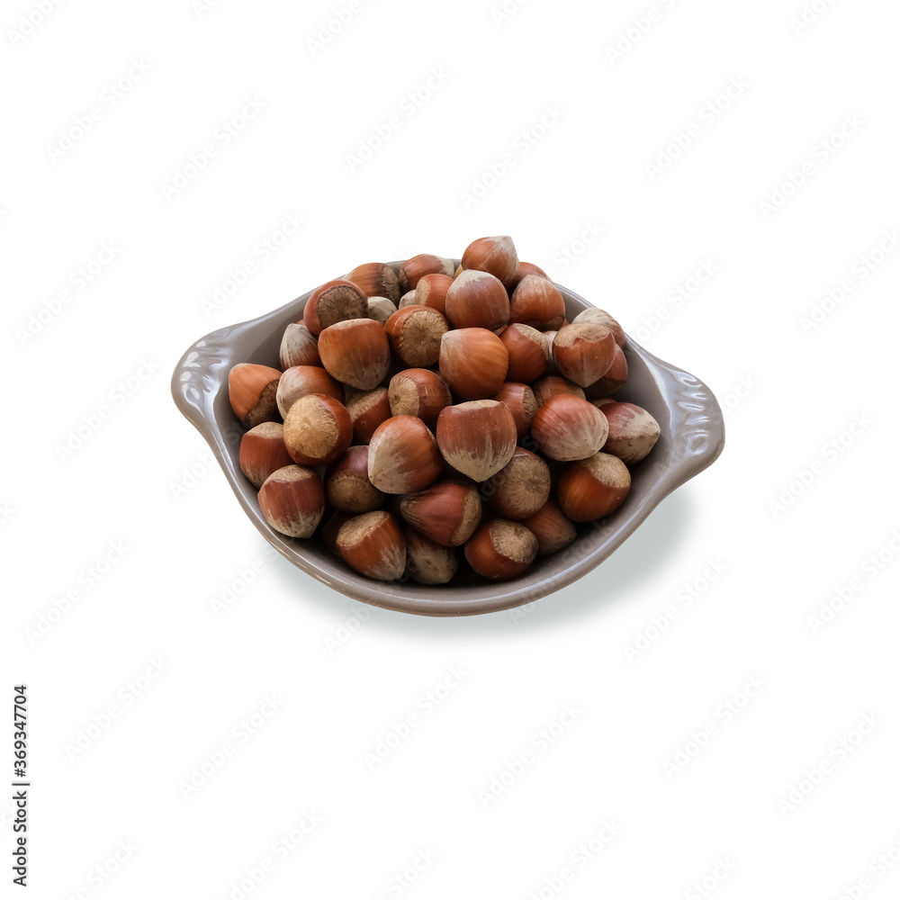 Hazelnuts in a shell on a grey plate isolated object minimalist concept of healthy food diet and eco-friendly lifestyle Hazelnuts in a shell on a grey plate isolated object minimalist concept of healthy food diet and eco-friendly lifestyle