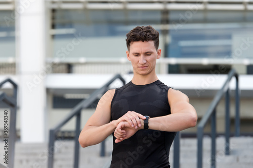 healthy life and self-control concept. Staying fit and healthy. Man running athlete looking at smartwatch GPS heart rate monitor smart watch. Trail runner looks at heart rate monitor clock