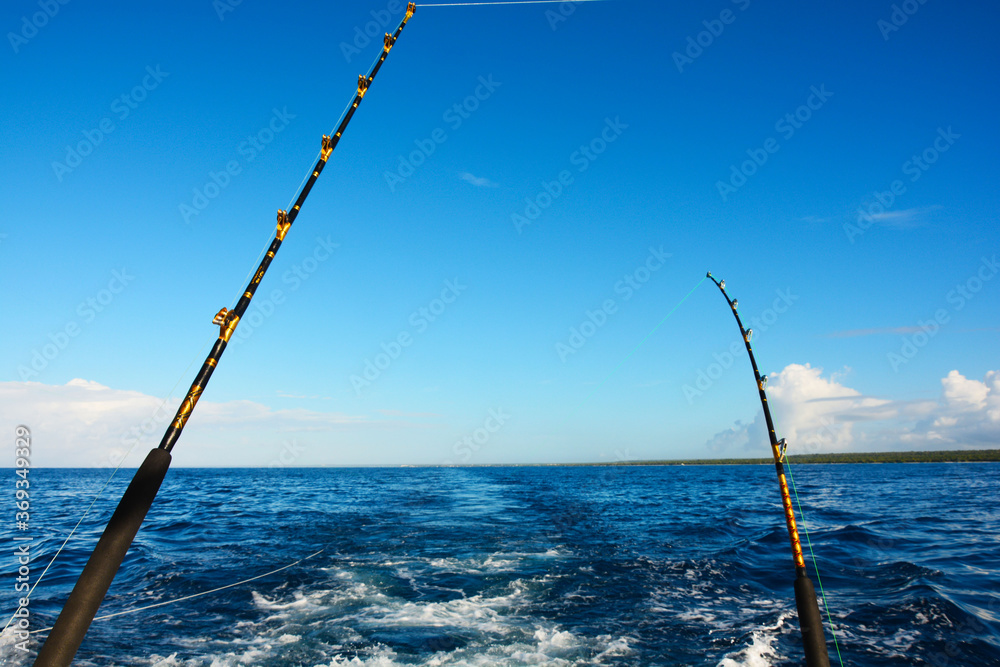 Fototapeta premium Two fishing rods on a boat in the ocean