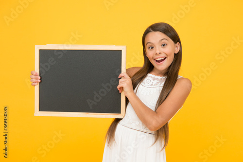 Good news for you. Chalkboard for information. Blank blackboard. Something you need to know. Happy smiling girl hold blackboard. Small kid with blank blackboard. Advertisement promotion copy space