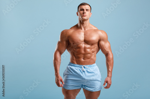 Quadro em tela Handsome muscular man naked torso abs, isolated on blue background