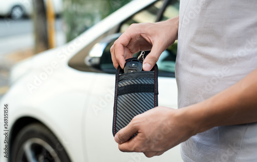 Man using RFID protection pouch for car key, anti-theft RFID key pouch. photo