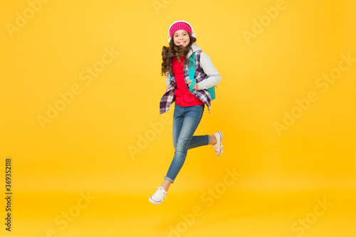 Life is a daring adventure. Happy child jump yellow background. Energetic girl wear backpack in casual style. Childhood adventure. Autumn vacation. Adventure fun. Enjoying playful day