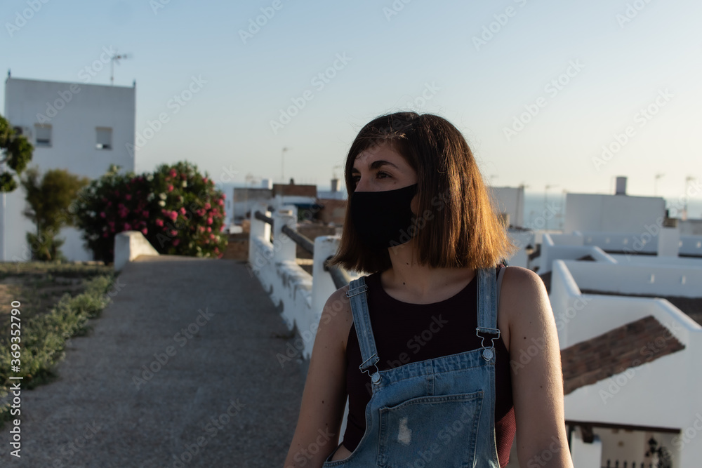Attractive young female wearing a face mask while visiting a small village in Cadiz, Spain