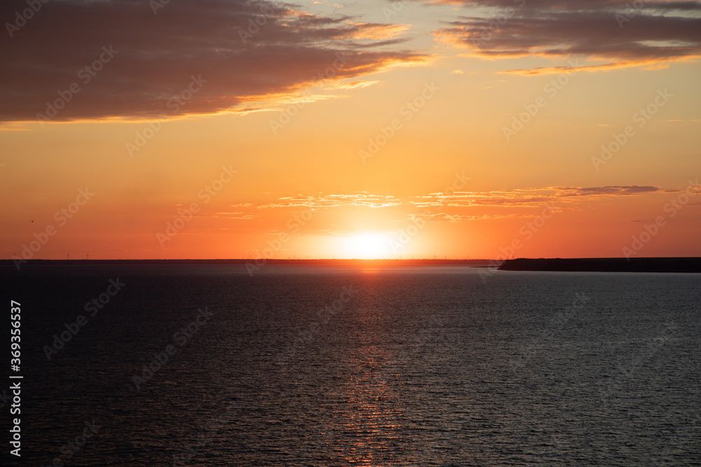 Beautiful sunset above the sea. Idyllic shot of sunset by the sea waters, warm orange and red colors Beautiful sunset above the sea. Idyllic shot of sunset by the sea waters, warm orange and red colors