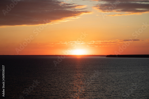 Beautiful sunset above the sea. Idyllic shot of sunset by the sea waters, warm orange and red colors © Olena