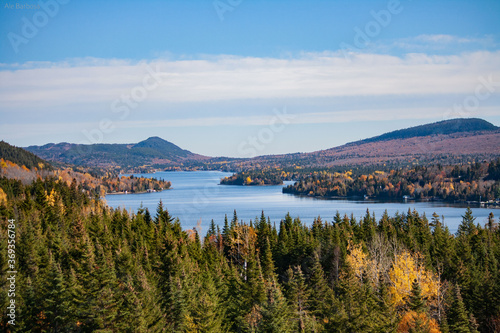 beautiful scenery, autumn in Canada, yellow trees, oranges, greens, sky, a beautiful lake 