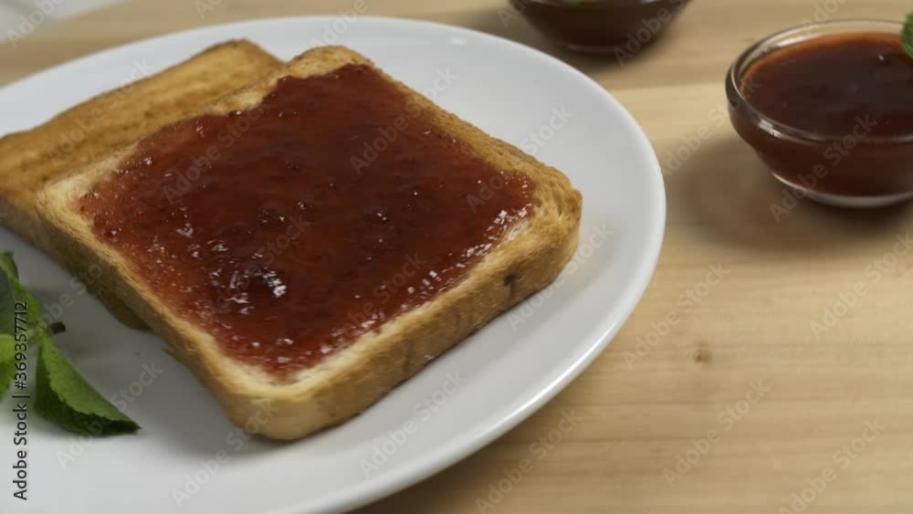 Rotating board with toasted bread and strawberry jam Rotating board with toasted bread and strawberry jam
