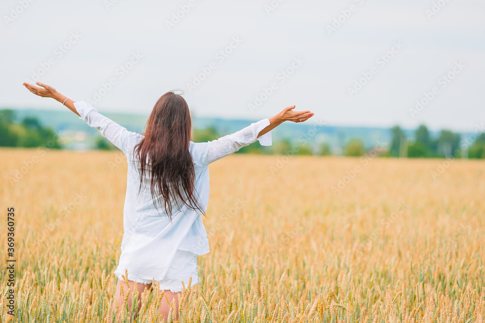 Romantic woman walking in golden fields of wheat Romantic woman walking in golden fields of wheat