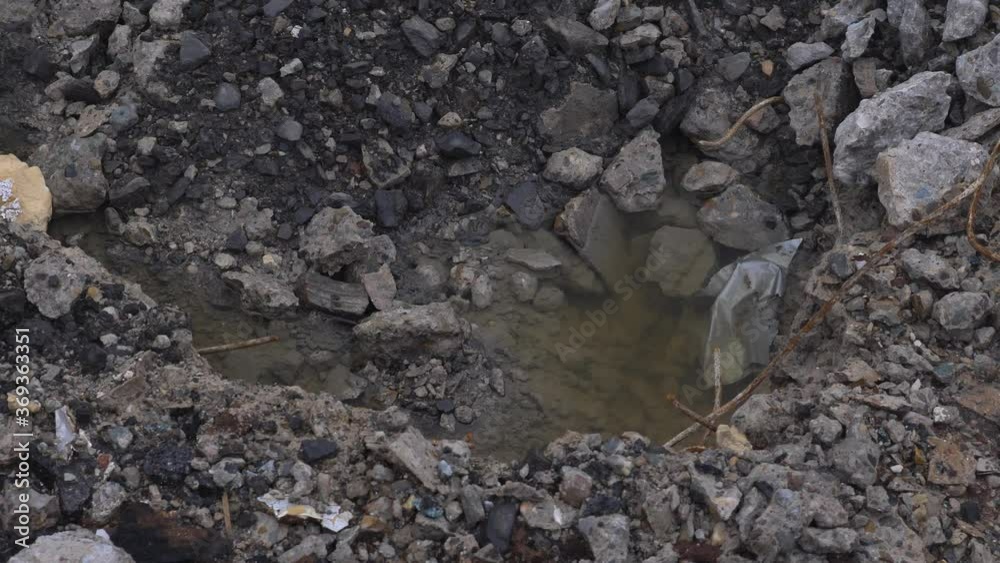 A water filled crater of rubble from a demolished building, shot could represent a demolition in progress or damage from conflict/war A water filled crater of rubble from a demolished building, shot could represent a demolition in progress or damage from conflict/war
