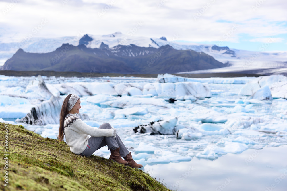 Fototapeta premium Iceland tourist enjoying Jokulsarlon glacial lagoon. Woman visiting destination landmark attraction glacier lake, Iconic Vatnajokull nature landscape.