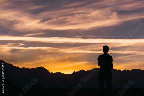 young man standing in the golden hour in front of the Andes mountain r photo