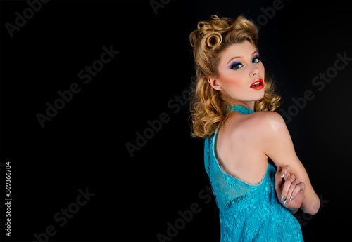 Pin up woman portrait. Beautiful retro female with red lips and old fashion hairstyle. Studio shot on black background.
