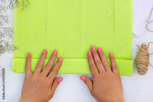 Fotografi Step by step tutorial on making a light green fluffy pom-pom from tissue paper
