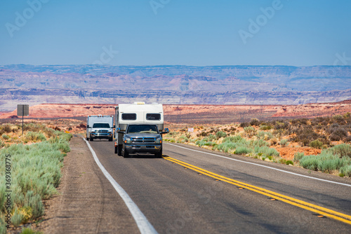 RV Camper Van on the Road. Exploring the USA. Holiday American trip. Motorhome, caravan on a road. Vehicle motor home trailer on road in America.