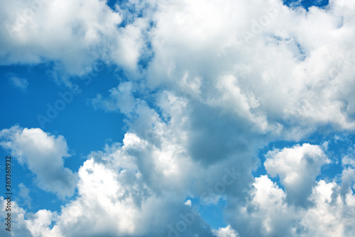 Fluffy white clouds on background of blue sky. Wallpaper.