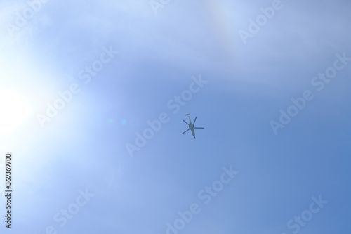 晴れの空の真上を飛行するヘリコプター