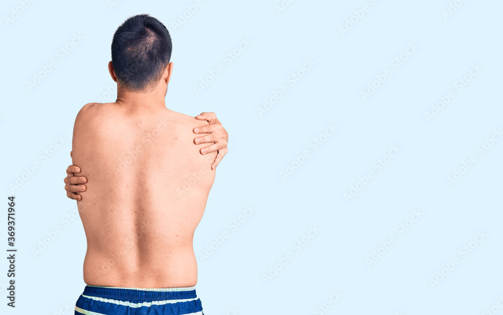 © Krakenimages.com - Young handsome man wearing swimwear hugging oneself happy and positive from backwards. self love and self care