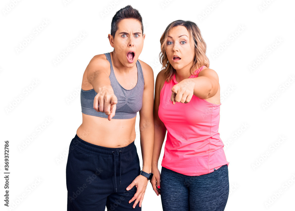 Couple of women wearing sportswear pointing displeased and frustrated to the camera, angry and furious with you Couple of women wearing sportswear pointing displeased and frustrated to the camera, angry and furious with you