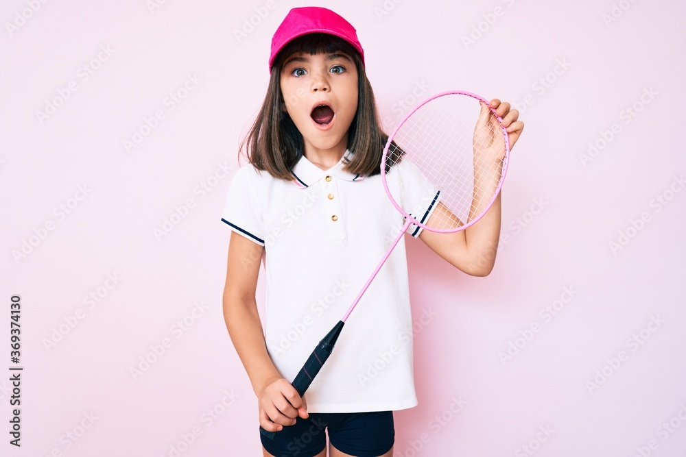 Young little girl with bang holding badminton racket celebrating crazy and amazed for success with open eyes screaming excited. Young little girl with bang holding badminton racket celebrating crazy and amazed for success with open eyes screaming excited.