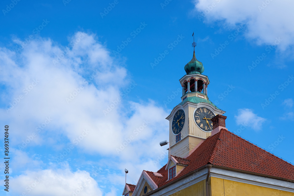 Old town hall with clocktower in Rauma city, Finland against a blue sky with white clouds. Copy space.
