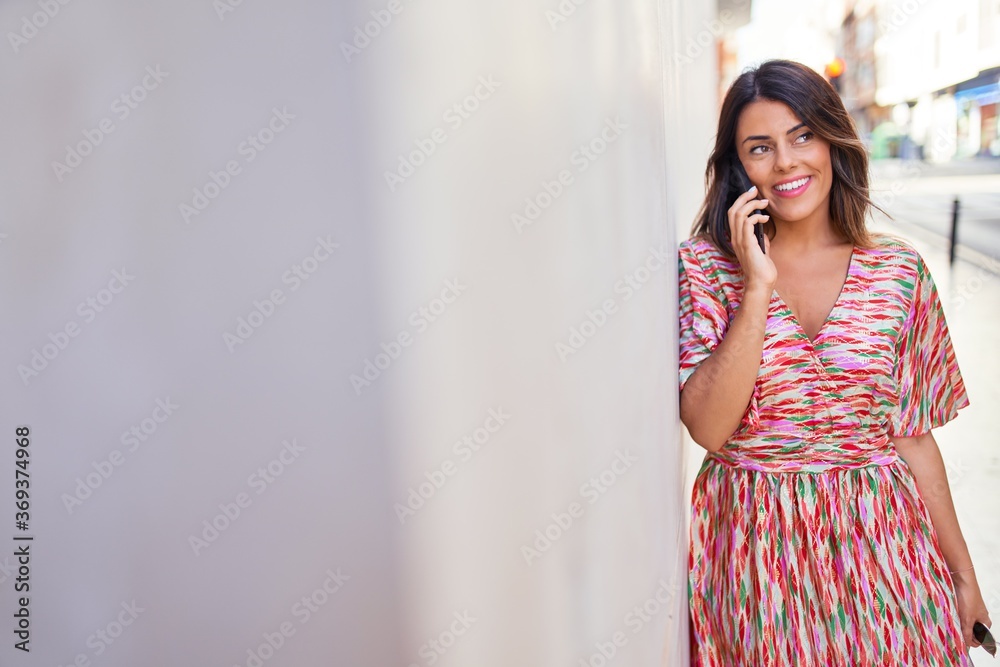 Beautiful young woman wearing fashionable clothes walking down the street and using smartphone telephone Beautiful young woman wearing fashionable clothes walking down the street and using smartphone telephone