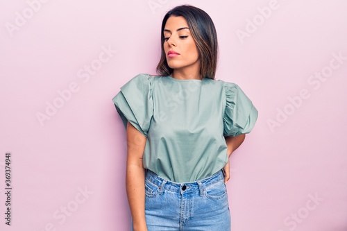 Young beautiful brunette woman wearing casual clothes standing over isolated pink background