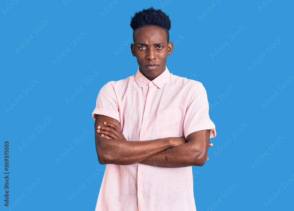 Young african american man wearing casual clothes skeptic and nervous, disapproving expression on face with crossed arms. negative person. Young african american man wearing casual clothes skeptic and nervous, disapproving expression on face with crossed arms. negative person.