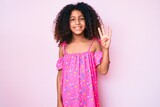African american child with curly hair wearing casual dress showing and pointing up with fingers number four while smiling confident and happy.