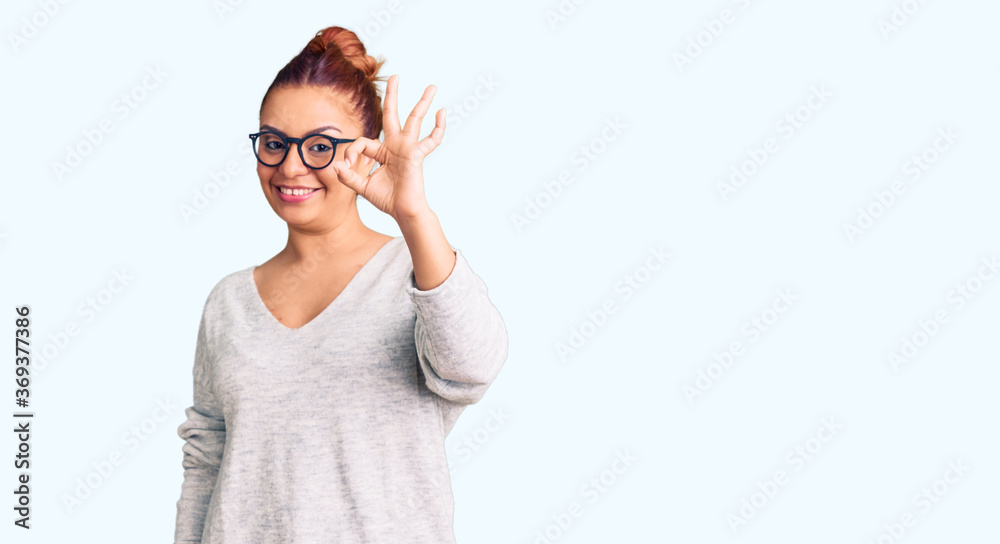 Young latin woman wearing casual clothes smiling positive doing ok sign with hand and fingers. successful expression.